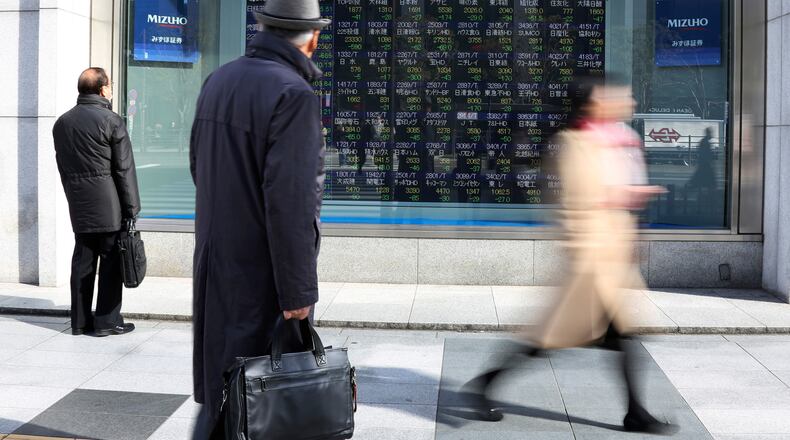 People look at an electronic stock board of a securities firm in Tokyo Monday. Asian shares opened sharply lower Monday, extending global stock losses after Wall Street’s big selloff. AP Photo/Koji Sasahara)