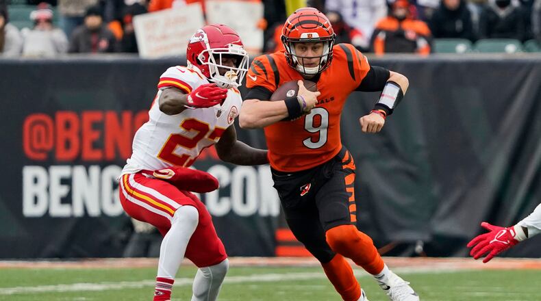 Cincinnati Bengals quarterback Joe Burrow (9) scrambles against Kansas City Chiefs cornerback Rashad Fenton (27) during the first half of an NFL football game, Sunday, Jan. 2, 2022, in Cincinnati. (AP Photo/Jeff Dean)