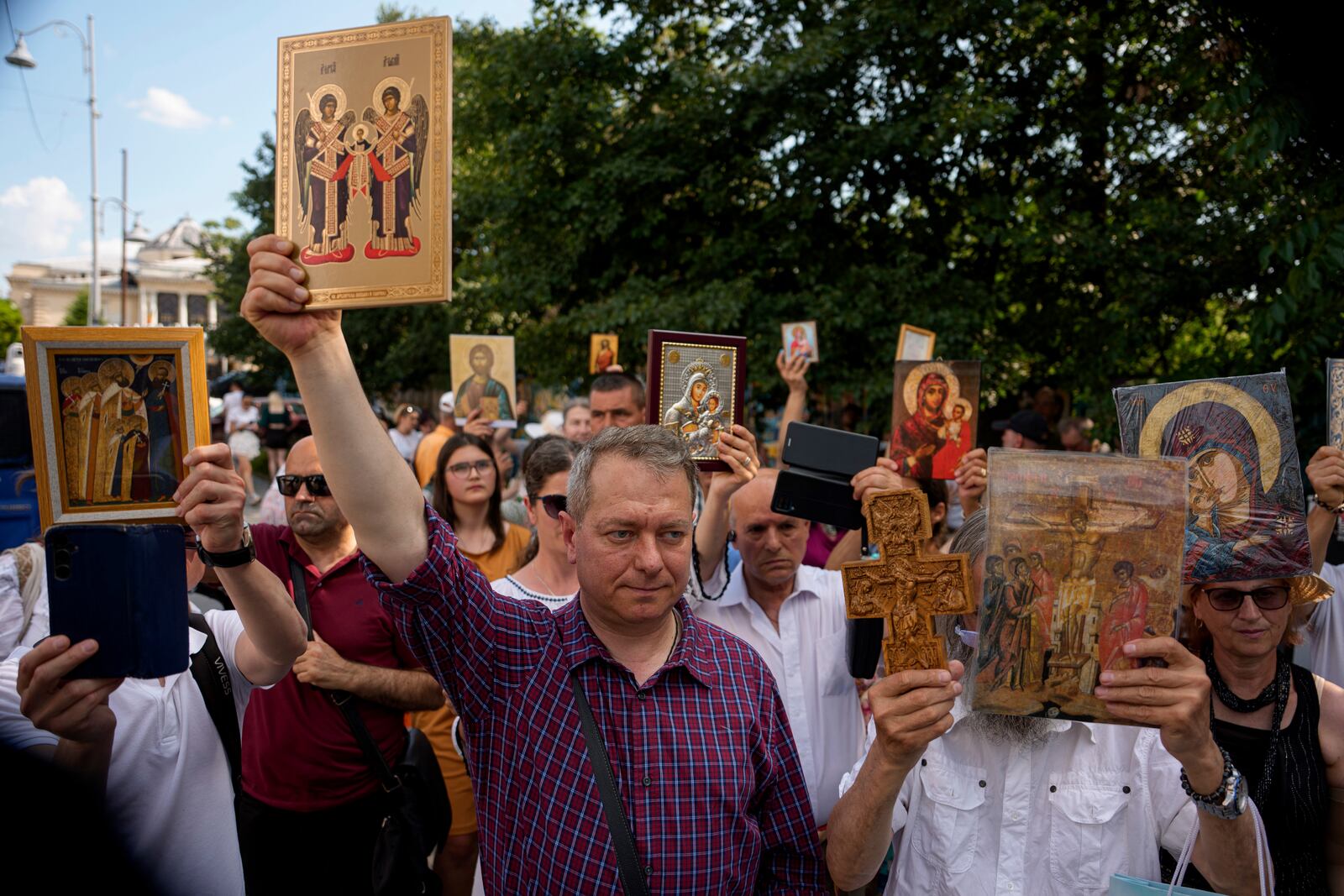 Opponents of gay rights hold religious icons during the Bucharest Pride Parade in Bucharest, Romania, Saturday, June 7, 2025. (AP Photo/Andreea Alexandru)