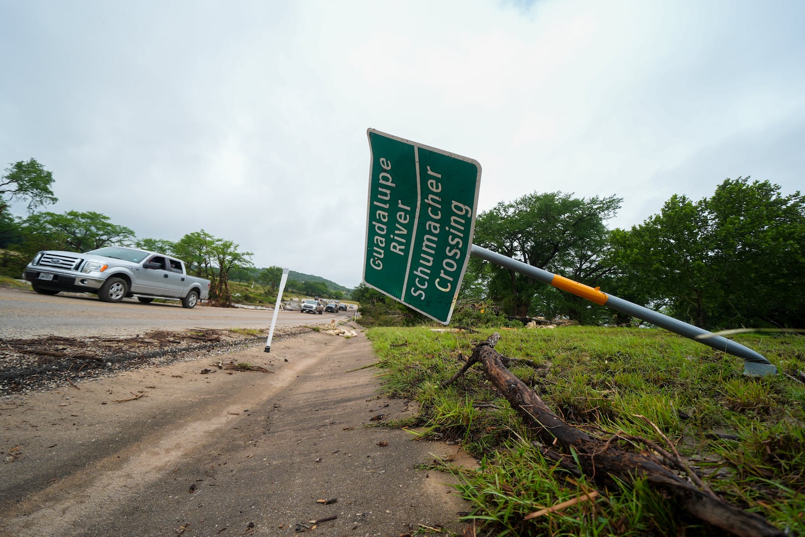 A downed sign is seen near a crossing of the Guadalupe River after a flash flood swept through the area Saturday, July 5, 2025, in Ingram. (AP Photo/Julio Cortez)