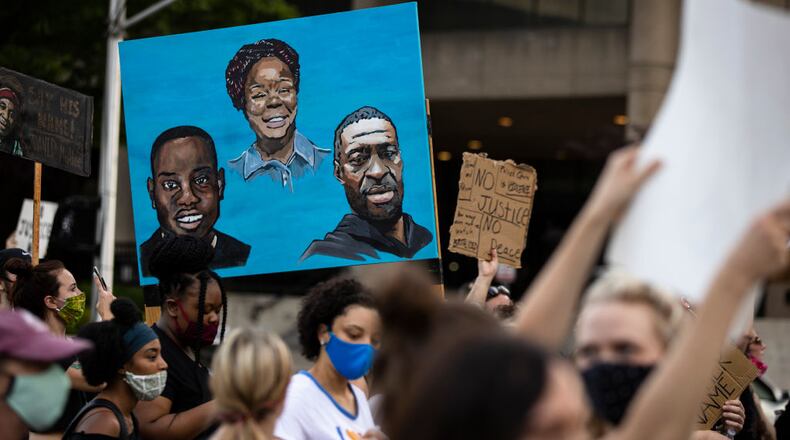 LOUISVILLE, KY - JUNE 05: Protesters carry a painting of (L-R) Ahmaud Arbery, Breonna Taylor and George Floyd while marching on June 5, 2020 in Louisville, Kentucky. Protests across the country continue into their second weekend after recent police-related incidents resulting in the deaths of African-Americans Breonna Taylor in Louisville and George Floyd in Minneapolis, (Photo by Brett Carlsen/Getty Images)