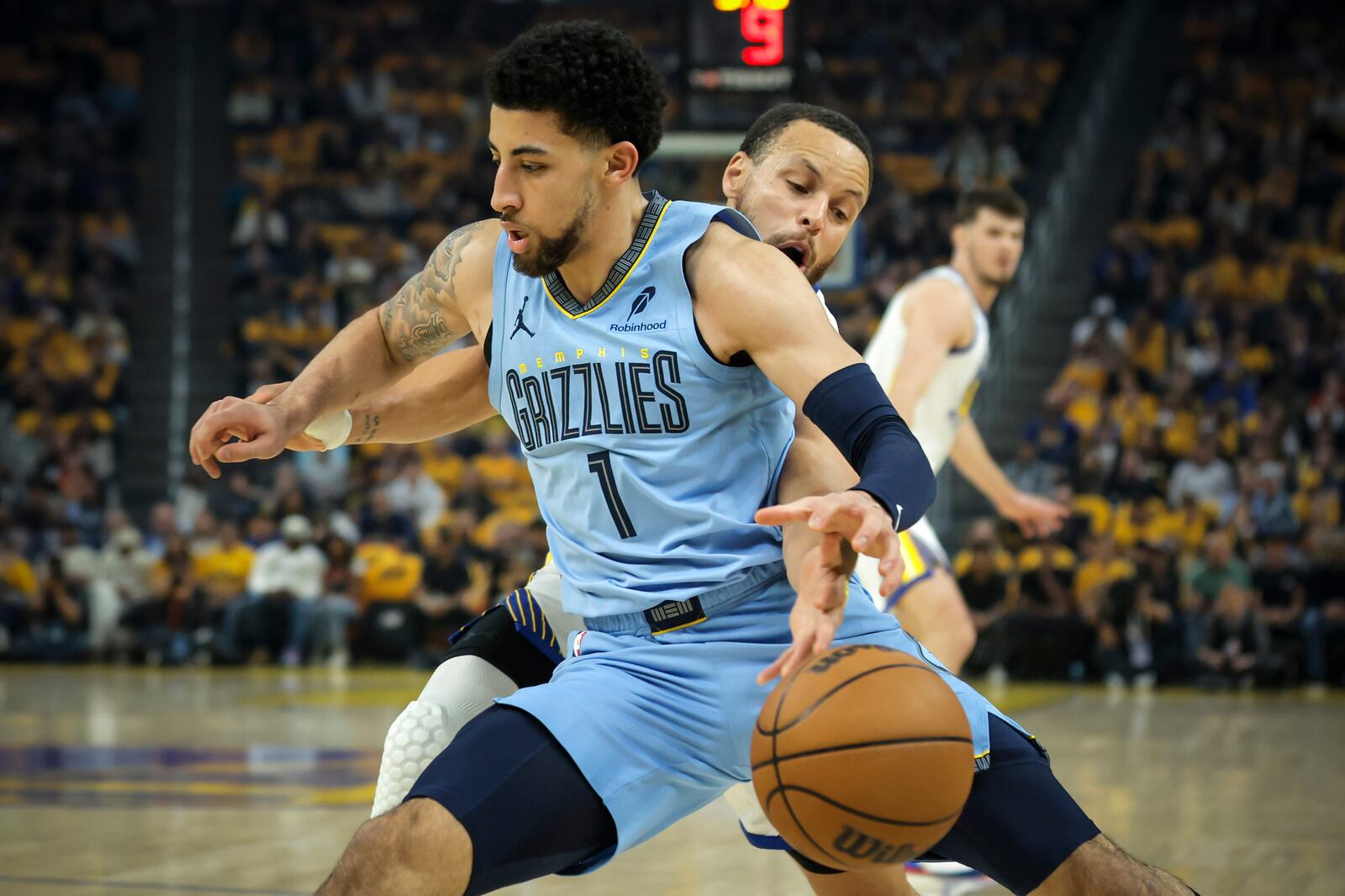 Golden State Warriors' Stephen Curry, back, pokes the ball away from Memphis Grizzlies' Scotty Pippen Jr. (1) in the first half of an NBA play-in tournament basketball game in San Francisco, Tuesday, April 15, 2025. (Scott Strazzante/San Francisco Chronicle via AP)