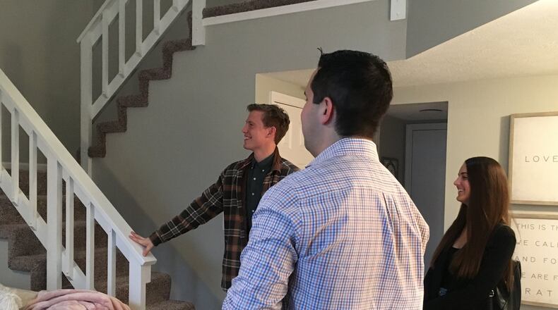 Engaged couple Ryan Runyeon and Malloree Hagerty, both millennials, are looking to buy a home. Realtor Austin Castro shows the pair some options in Centerville. STAFF PHOTO / HOLLY SHIVELY