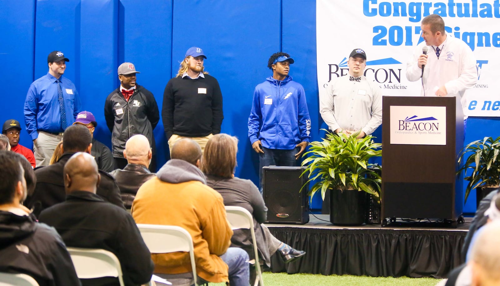 Hamilton football coach Chad Murphy introduces Big Blue players (from left to right) Grant Fansler, Eric Jackson, Alex Little, Vince Sanford and Conner Gleason during the National Signing Day event hosted by the Greater Miami Conference football coaches at Beacon Orthopaedics & Sports Medicine in Sharonville on Wednesday. GREG LYNCH/STAFF