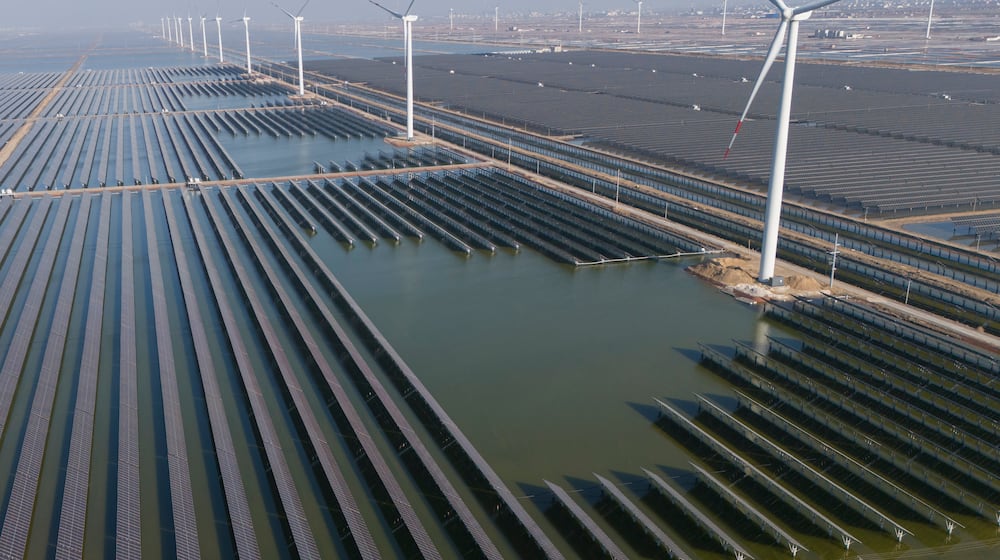 FILE - Wind turbines operate along a solar farm near Weifang in eastern China's Shandong province on March 22, 2024. (AP Photo/Ng Han Guan, File)