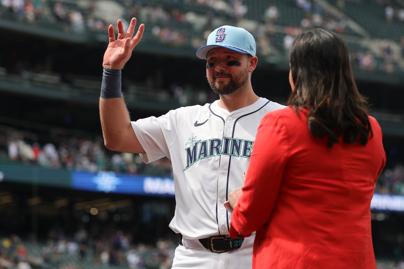 Seattle Mariners catcher Cal Raleigh, left, gestures to fans during an interview after his team's win in a baseball game against the Pittsburgh Pirates, Friday, July 4, 2025, in Seattle. (AP Photo/Ryan Sun)