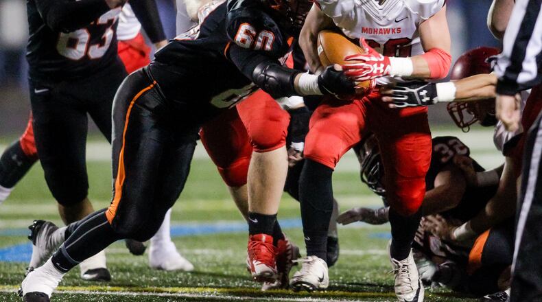Madison’s Cameron Svarda carries the ball as he is hit by Wheelersburg’s Evan Dahm during their Division V state semifinal Nov. 24, 2017, at Herrnstein Field in Chillicothe. NICK GRAHAM/STAFF