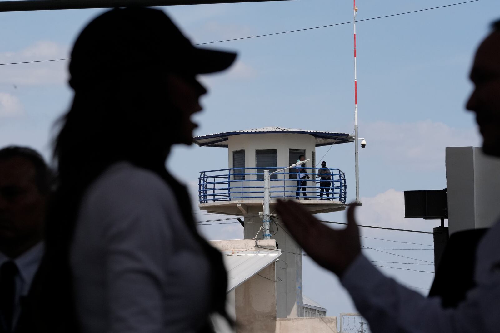 Guards patrol from a prison watchtower as Homeland Security Secretary Kristi Noem, left, and Minister of Justice and Public Security Héctor Villatoro, tour the Terrorist Confinement Center in Tecoluca, El Salvador, Wednesday, March 26, 2025. (AP Photo/Alex Brandon)
