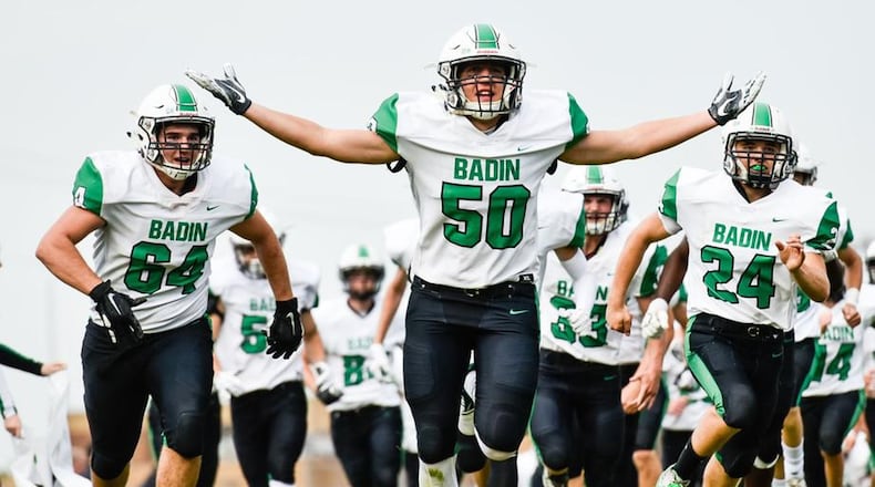 Badin’s Andrew Jones (64), John Berg (50) and Ben Grawe (24) lead their team onto the field for the season opener at Ross on Aug. 24. Badin won 41-20. NICK GRAHAM/STAFF