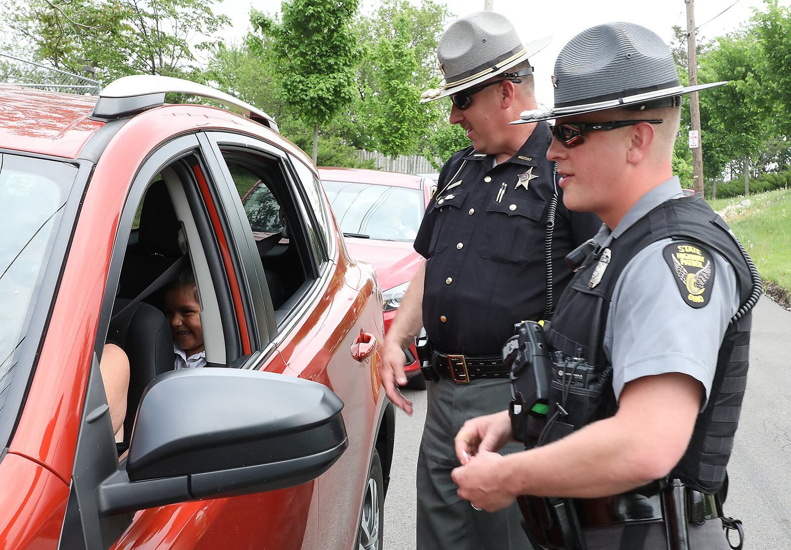 Clark County Sheriff’s Deputy Mark Lane and Sgt. Merrill Thompson of the Ohio State Highway Patrol check drivers to make sure they are wearing their seatbelts as they leaving Catholic Central High School. The safety check kicked off their Click It Or Ticket campaign that runs through June 4. Bill Lackey/Staff
