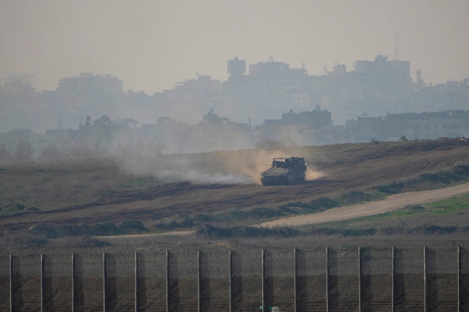 FILE - An Israeli army vehicle moves in the Gaza Strip as seen from southern Israel, Jan. 16, 2025. (AP Photo/Ariel Schalit, File)