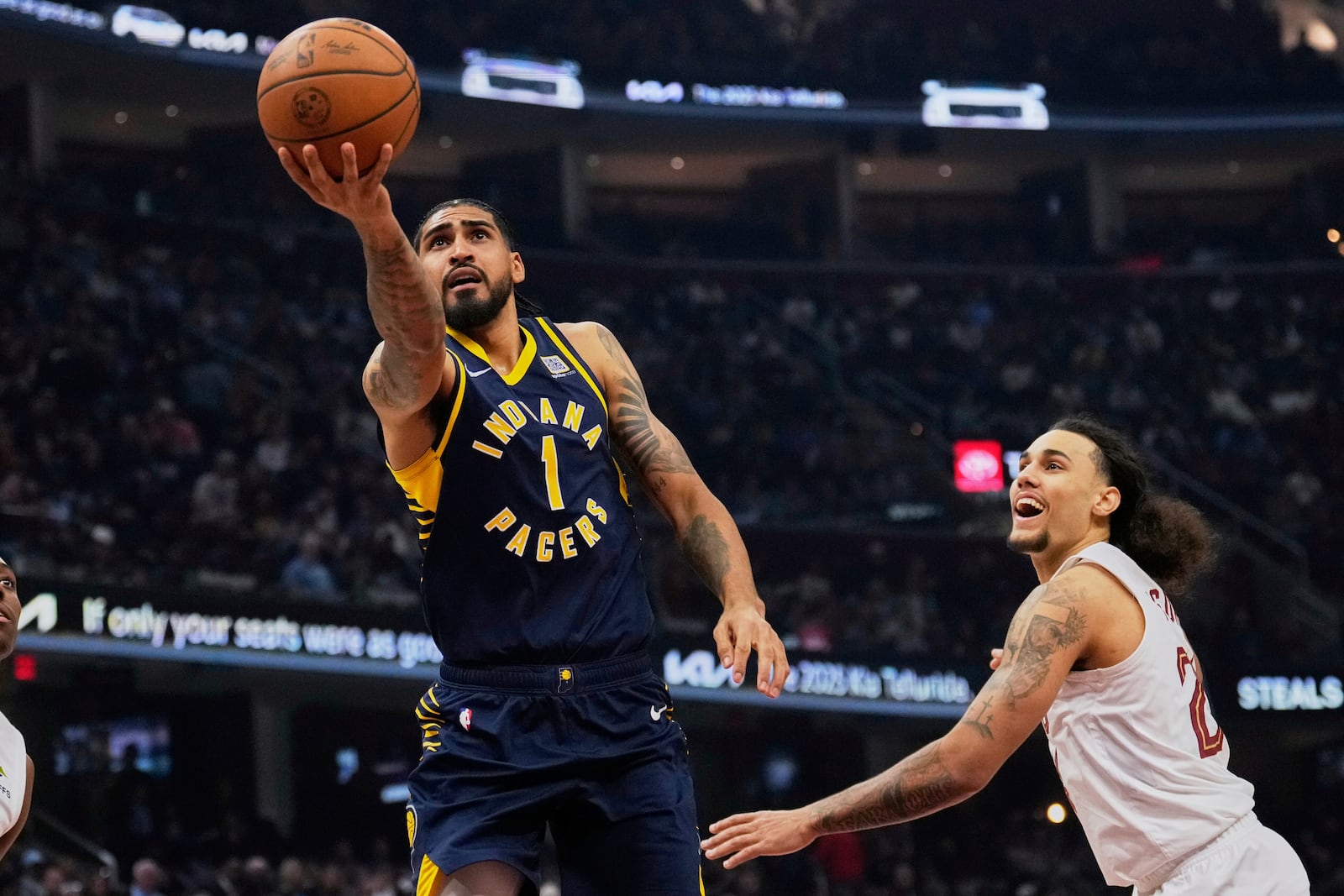 Indiana Pacers forward Obi Toppin (1) goes to the basket past Cleveland Cavaliers forward Jaylon Tyson, right, in the first, half of an NBA basketball game Sunday, April 13, 2025, in Cleveland. (AP Photo/Sue Ogrocki)