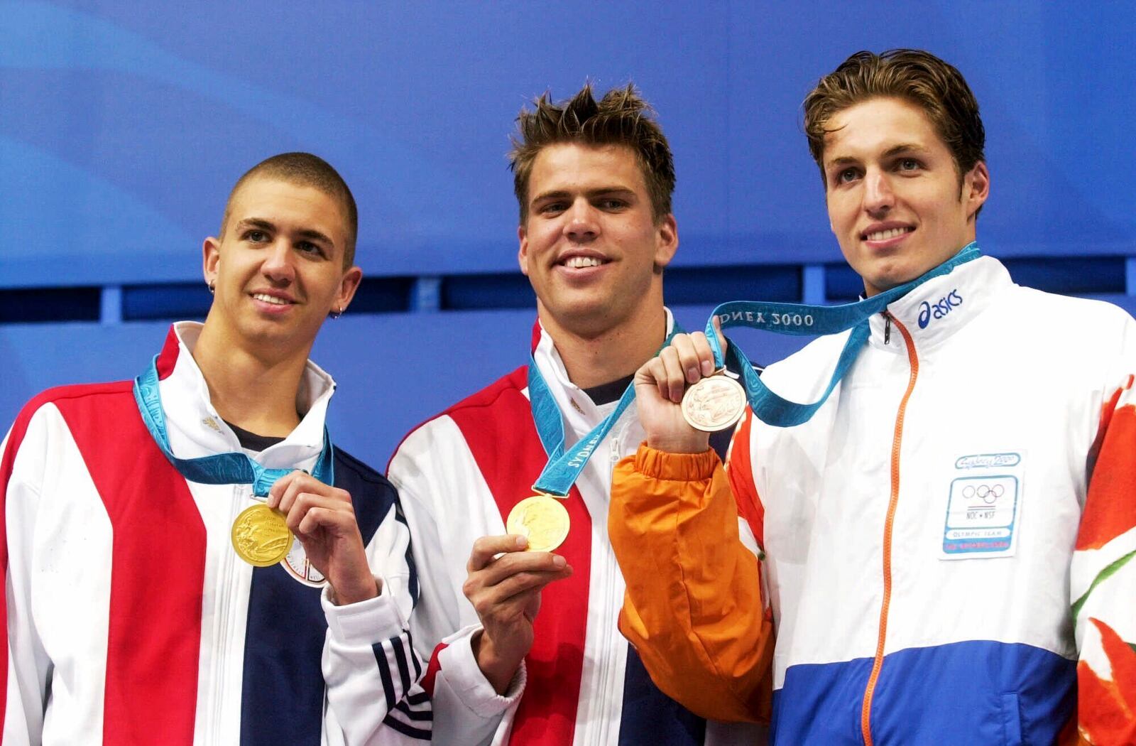 FILE - U.S. swimmers Anthony Ervin, left, and Gary Hall Jr., center, who tied for the gold medal in the men's 50m freestyle, stand with Dutch swimmer Pieter van den Hoogenband, right, who won the bronze medal, Sept. 22, 2000 at the Sydney International Aquatic Center during the Summer Olympics in Sydney. (AP Photo/David Longstreath, file)