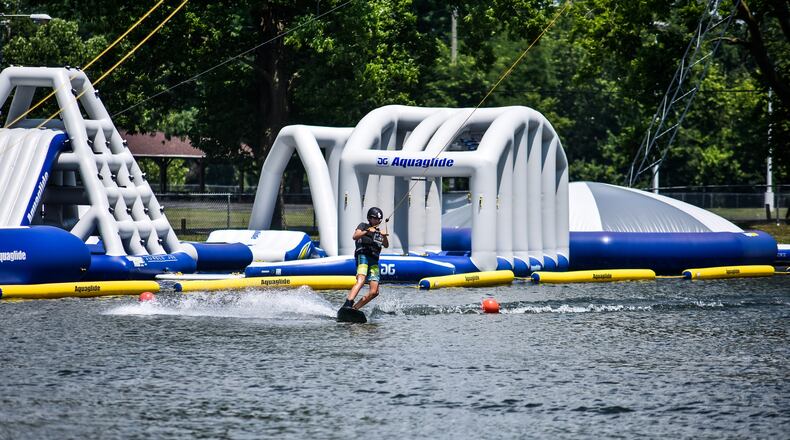 Participants learn new tricks at a wakeboarding youth camp Tuesday, July 7, 2020 at Wake Nation Cincinnati on Joe Nuxhall Boulevard in Fairfield. Wake Nation has an overhead cable system to pull wakeboarders around the pond and have added to their inflatable aqua park this year for those who are not interested in wakeboarding. NICK GRAHAM / STAFF