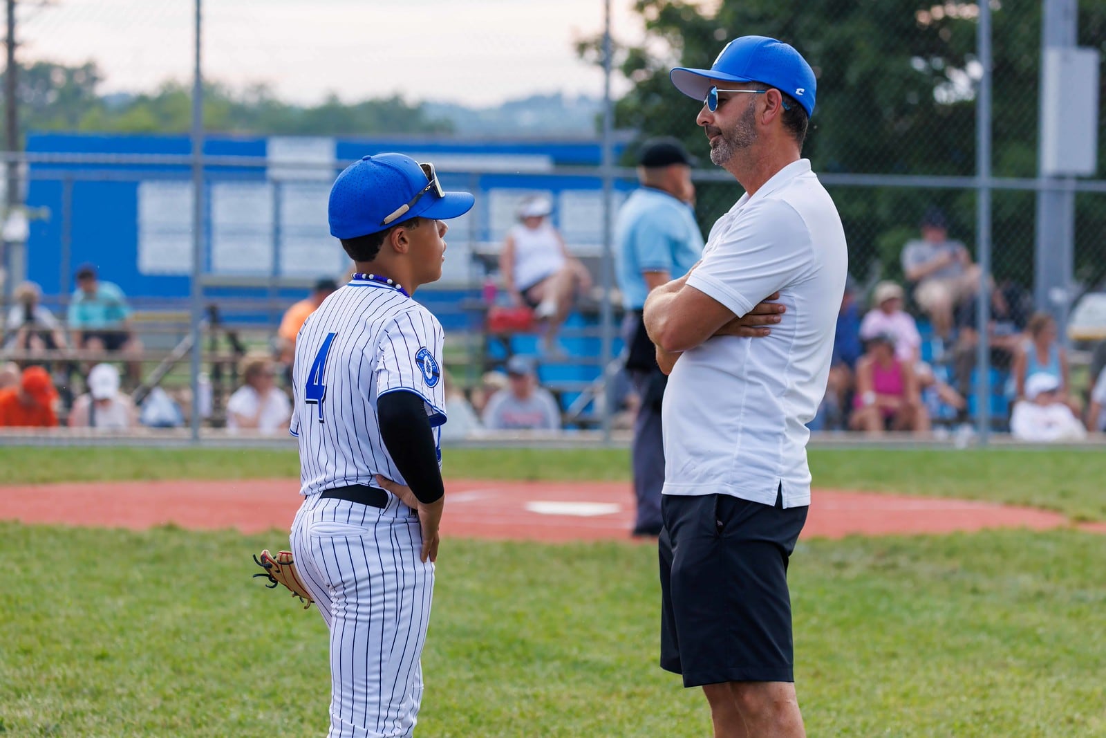 West Side manager Ken Coomer talks with TJ Madden (4) during their Ohio Little League District 9 tournament game against Loveland on Tuesday at West Side Little League. West Side won 14-0. TOM PATE / CONTRIBUTED