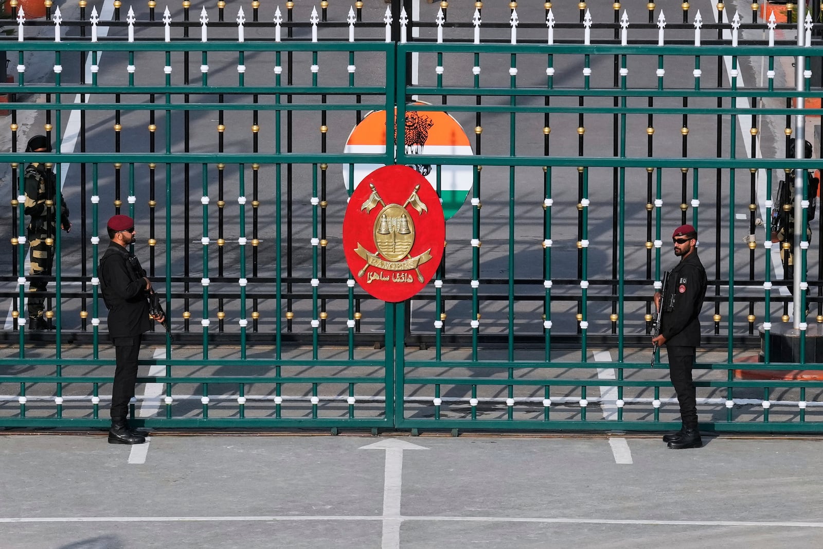 Pakistan's Rangers soldiers, in black, and Indian Border Security Forces soldiers, behind the gate, stand guard during a daily closing ceremony at the Wagah, a joint post on the Pakistan and India border, near Lahore, Pakistan, Monday, May 5, 2025. (AP Photo/K.M. Chaudary)