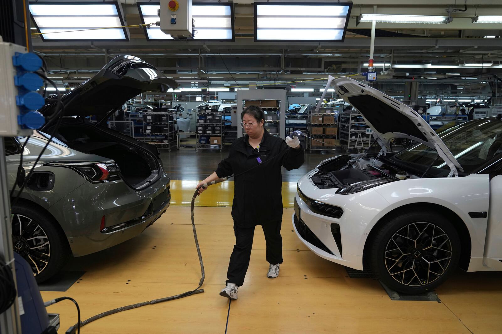 A worker checks coolant system on the Zeekr 001 EV models at the Chinese automaker Zeekr assembly plant, in Ningbo, east China's Zhejiang Province on April 16, 2025. (AP Photo/Andy Wong)