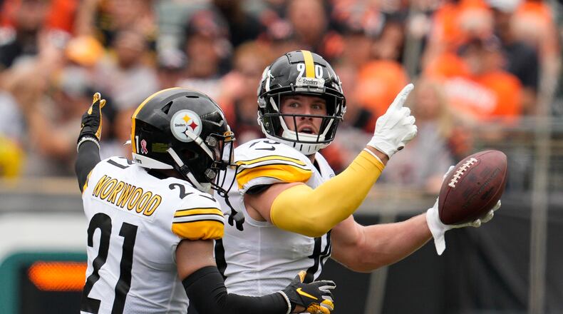 Pittsburgh Steelers linebacker T.J. Watt (90) celebrates after an interception with safety Tre Norwood (21) during the first half of an NFL football game against the Cincinnati Bengals, Sunday, Sept. 11, 2022, in Cincinnati. (AP Photo/Jeff Dean)