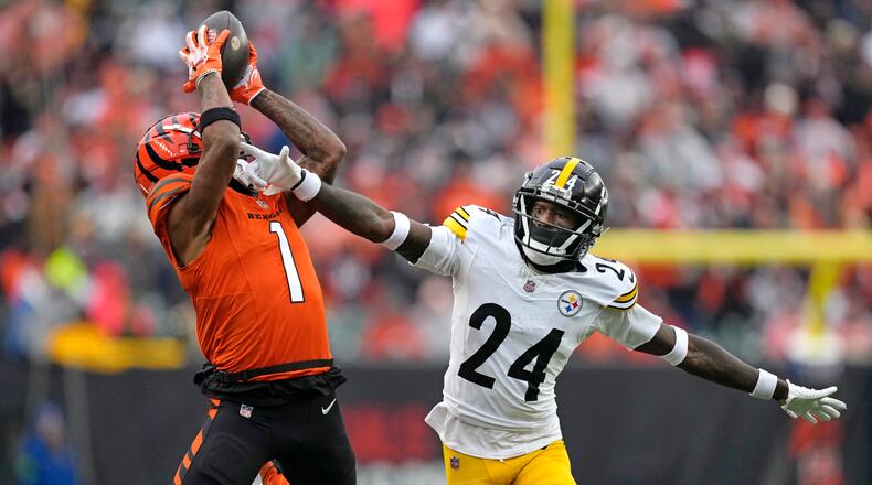 Cincinnati Bengals wide receiver Ja'Marr Chase (1) catches a pass from quarterback Jake Browning for a first down with Pittsburgh Steelers cornerback Joey Porter Jr. (24) defending during the second half of an NFL football game in Cincinnati, Sunday, Nov. 26, 2023. (AP Photo/Carolyn Kaster)
