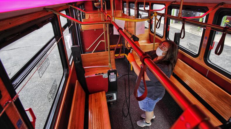 Susan Howard sprays disinfectant cleaner inside one of the Red Brick Express buses at their garage bus Tuesday, August 11, 2020 in Hamilton. NICK GRAHAM / STAFF