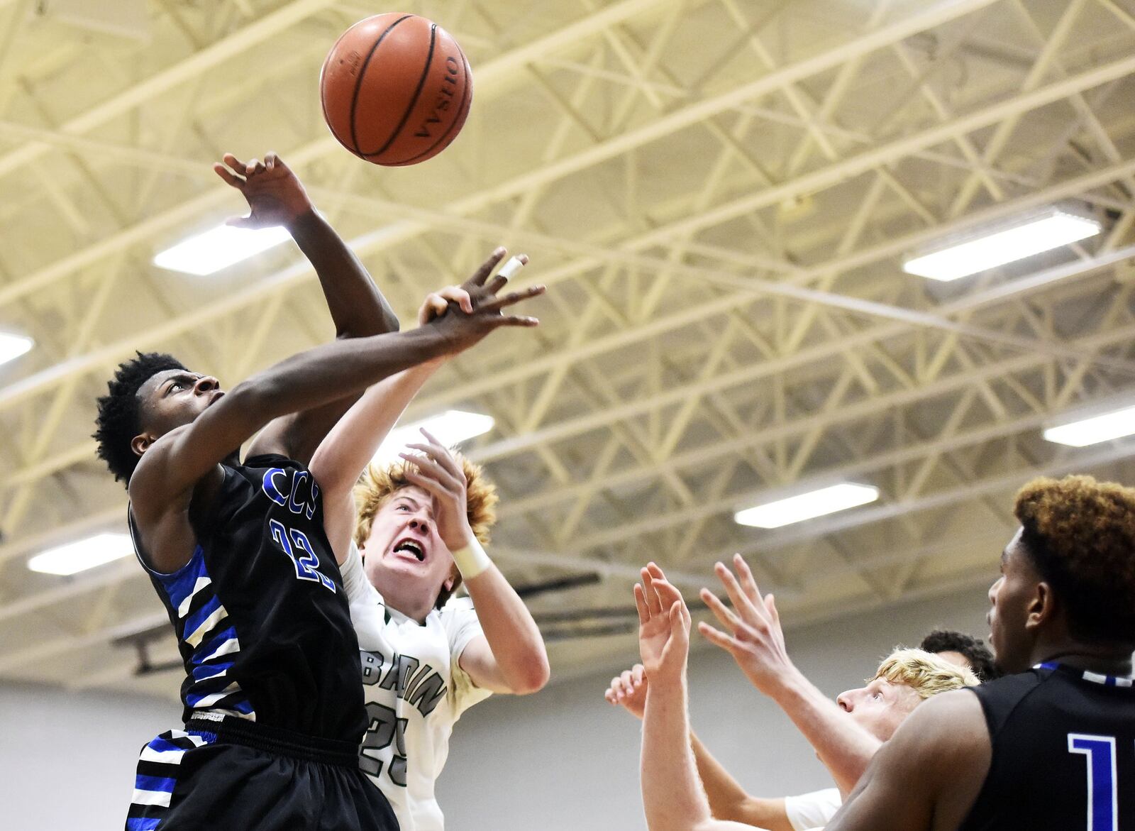 Badin’s Zachary Switzer (25) and Cincinnati Christian’s Josh Lawless (22) battle for a rebound during Friday night’s game at Mulcahey Gym in Hamilton. NICK GRAHAM/STAFF
