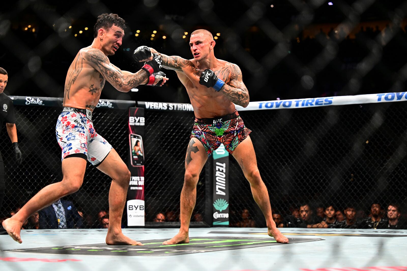 Dustin Poirier, right, hits Max Holloway in a lightweight title fight at UFC 318 in New Orleans, La., Saturday, July 19, 2025. (AP Photo/Ella Hall)