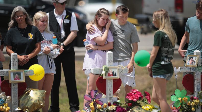 Mourners visit a memorial in front of Santa Fe High School on May 22, 2018 in Santa Fe, Texas. The makeshift memorial honors the victims of last Friday’s shooting when 17-year-old student Dimitrios Pagourtzis entered the school with a shotgun and a pistol and opened fire, killing 10 people. (Photo by Scott Olson/Getty Images)