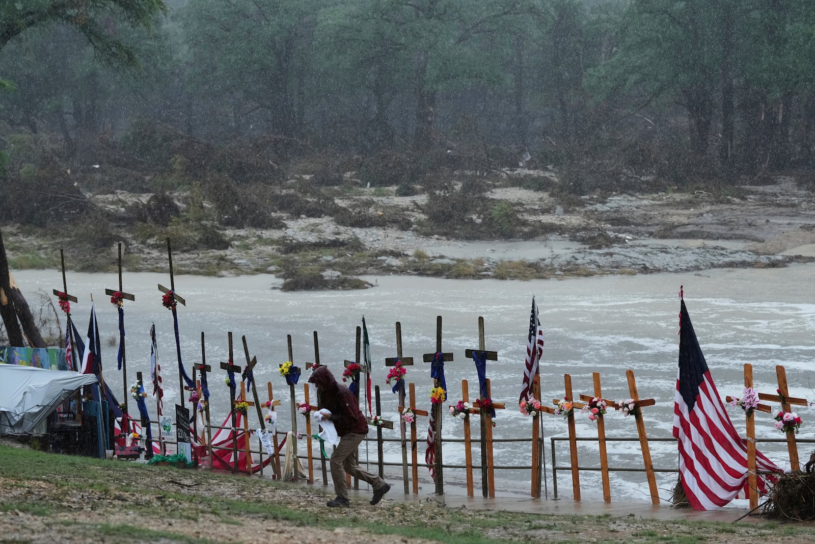 Rain falls over a make-shift memorial for flood victims along the Guadalupe River, Sunday, July 13, 2025, in Kerrville, Texas. (AP Photo/Eric Gay)