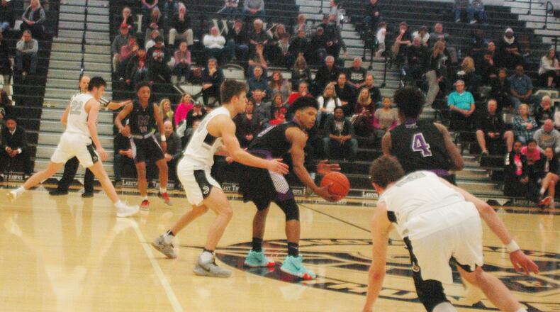 Middletown’s Kei’Aunte Powell (3) is about to hand the ball off to teammate Aaron Jones (4) as Lakota East’s Will Johnston (24) defends during Tuesday night’s game at East. The host Thunderhawks won 64-54. RICK CASSANO/STAFF