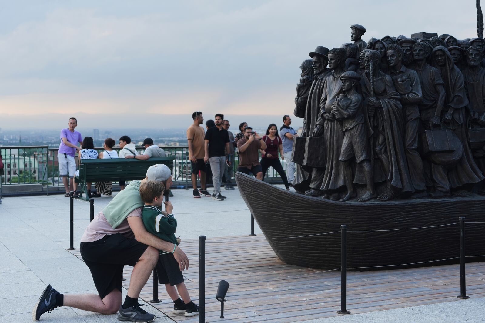 People look at a sculpture that pays tribute to migrants and refugees at the national shrine of Saint Joseph's Oratory of Mount Royal in Montreal, Saturday, June 28, 2025. (AP Photo/Luis Andres Henao)