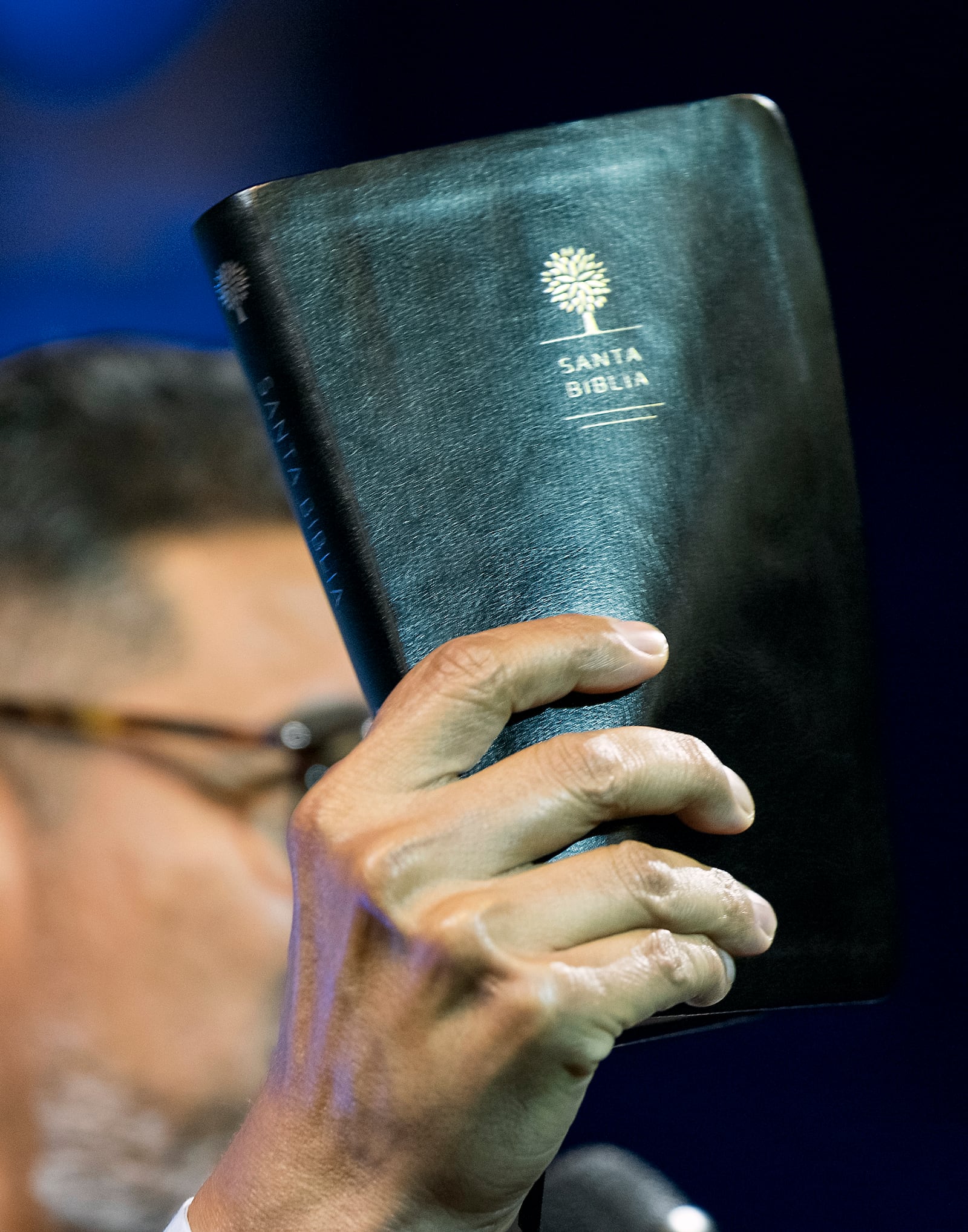 José Luis Orozco, a pastor from Nicaragua, holds up his bible as he ministers to members of the Oasis Church, in Taylor, Texas, June 15, 2025. (AP Photo/Rodolfo Gonzalez)