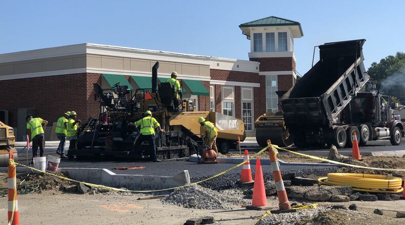 Workers added asphalt to the parking lot in front of the Performing Arts Center scheduled to open next week in Springboro. STAFF/LAWRENCE BUDD