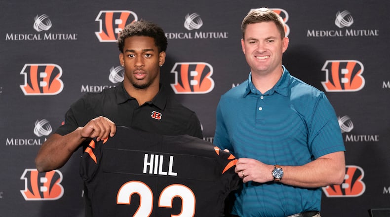 Cincinnati Bengals head coach Zac Taylor, right, holds up a team jersey with Daxton Hill for a photo after introducing Hill as the NFL football team's first-round pick during a news conference Friday, April 29, 2022, in Cincinnati. (AP Photo/Jeff Dean)