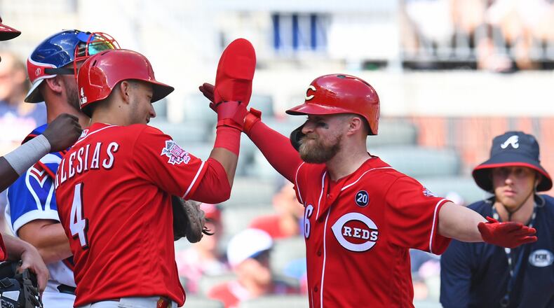 ATLANTA, GA - AUGUST 4: Tucker Barnhart #16 (R) of the Cincinnati Reds is congratulated by Jose Iglesias #4 after hitting a 10th inning three-run home run against the Atlanta Braves at SunTrust Park on August 4, 2019 in Atlanta, Georgia. (Photo by Scott Cunningham/Getty Images)