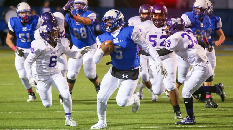 Middletown’s Marquise Petty (33) tries to bring down Hamilton quarterback Eric Jackson (5) during a game at Virgil Schwarm Stadium in Hamilton on Oct. 21, 2016. GREG LYNCH/STAFF