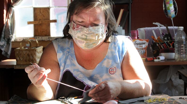 Liane Wagner, owner of Fairy Godmother Creations, hand sews hearts for a creation. MARSHALL GORBY / STAFF