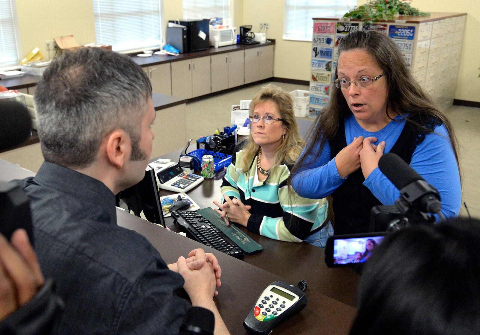 FILE - Rowan County Clerk Kim Davis, right, talks with David Moore following her office's refusal to issue marriage licenses at the Rowan County Courthouse in Morehead, Ky., on Sept. 1 2015. (AP Photo/Timothy D. Easley, File)