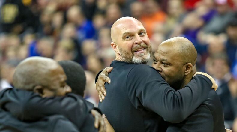 Trotwood-Madison High School boys basketball coach Rocky Rockhold (center) hugs Rams assistant coach Tony Clemens after the Rams beat Columbus South 77-73 in the Division II state championship game at the Ohio State University Jerome Schottenstein Center in Columbus. CONTRIBUTED PHOTO BY MICHAEL COOPER