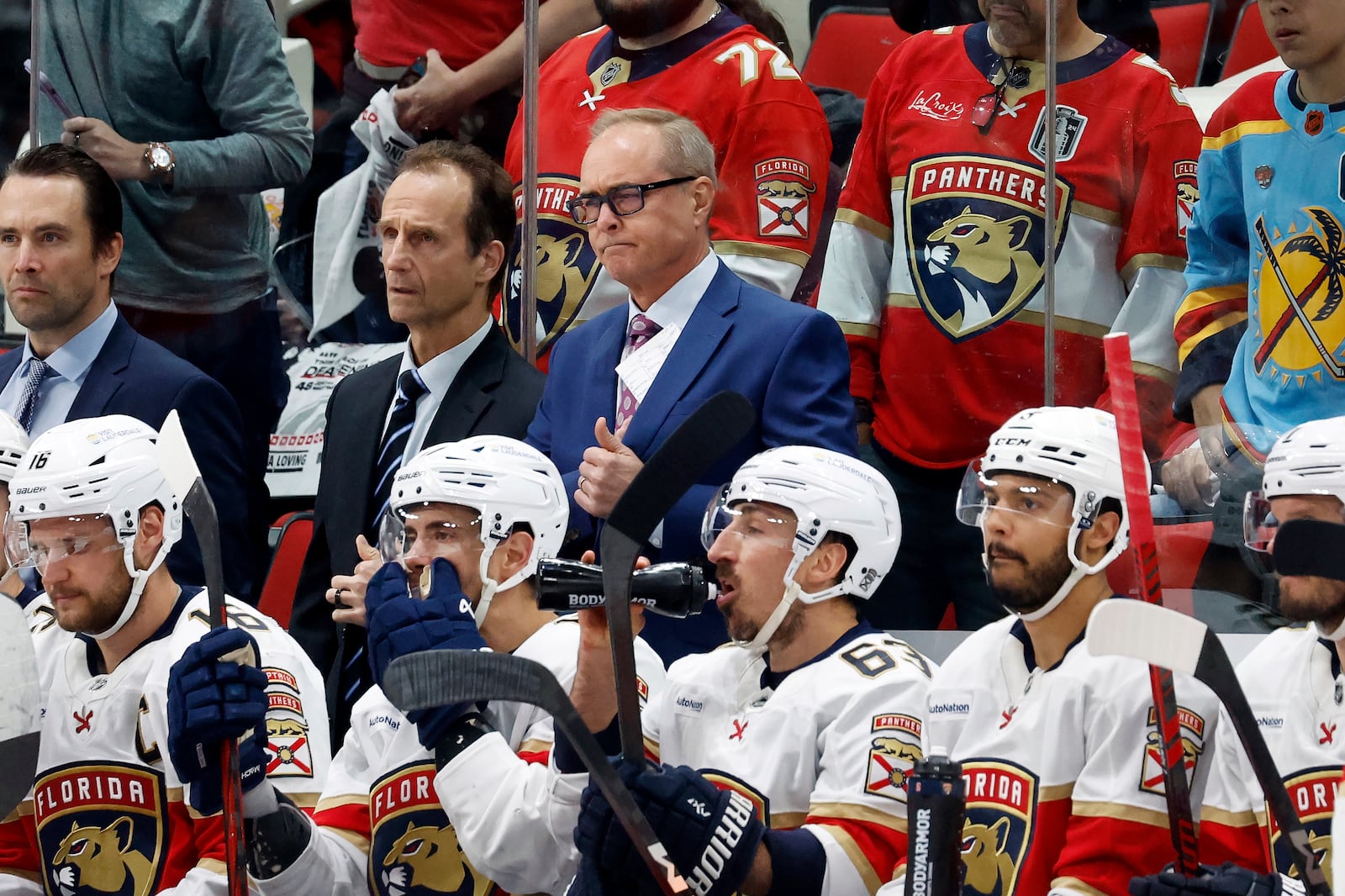 Florida Panthers head coach Paul Maurice, back center, waits for the results of his coaches challenge during the second period of Game 2 of the NHL hockey Stanley Cup Eastern Conference finals against the Carolina Hurricanes in Raleigh, N.C., Thursday, May 22, 2025. (AP Photo/Karl DeBlaker)