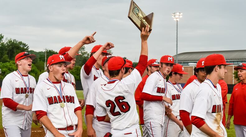 Madison’s players hoist the Division III district baseball championship trophy Wednesday after defeating Madeira 4-2 at Hamilton. NICK GRAHAM/STAFF
