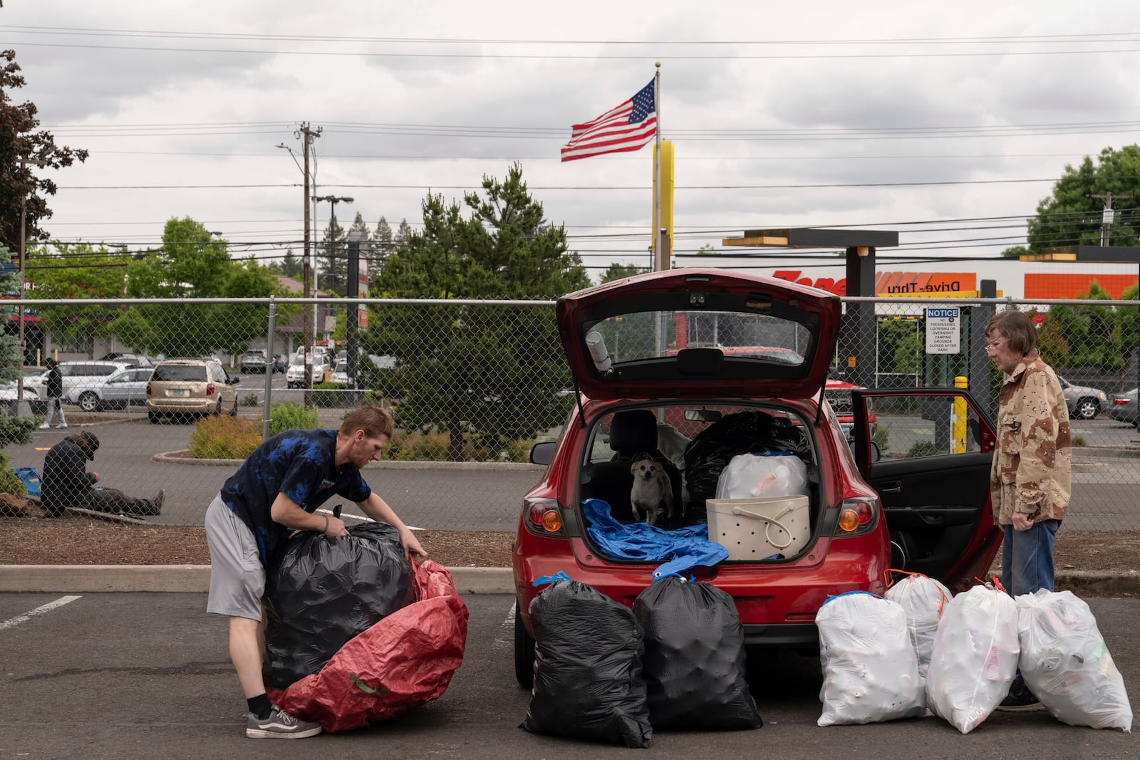 Chris Grass, left, and his father Todd Grass, right, prepare to take over 1,000 used beverage containers inside the Glisan BottleDrop Redemption Center on Thursday, May 15, 2025, in Portland, Ore. (AP Photo/Jenny Kane)