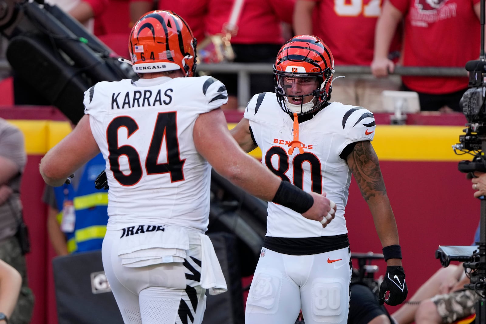 Cincinnati Bengals wide receiver Andrei Iosivas (80) is congratulated by teammate Ted Karras (64) after scoring during the second half of an NFL football game against the Kansas City Chiefs Sunday, Sept. 15, 2024, in Kansas City, Mo. (AP Photo/Charlie Riedel)