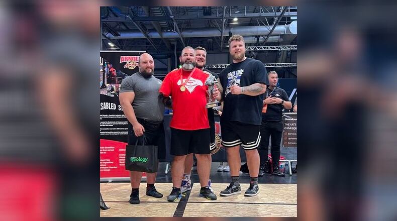 Surrounded by international strongmen stars, Middletown's Mike Diehl (center) accepts the second-place trophy last weekend in Great Britain. It was Diehl's fourth, disabled strongman international medal finish in the last year. (Provided Photo\Journal-News)