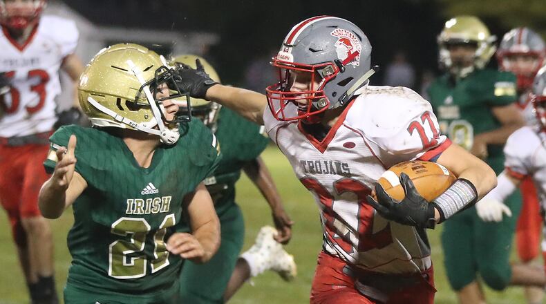 Southeastern’s Austin Sanders avoids a tackle by Catholic Central’s Mark Thrasher as he carries the ball during a game this season. BILL LACKEY/STAFF