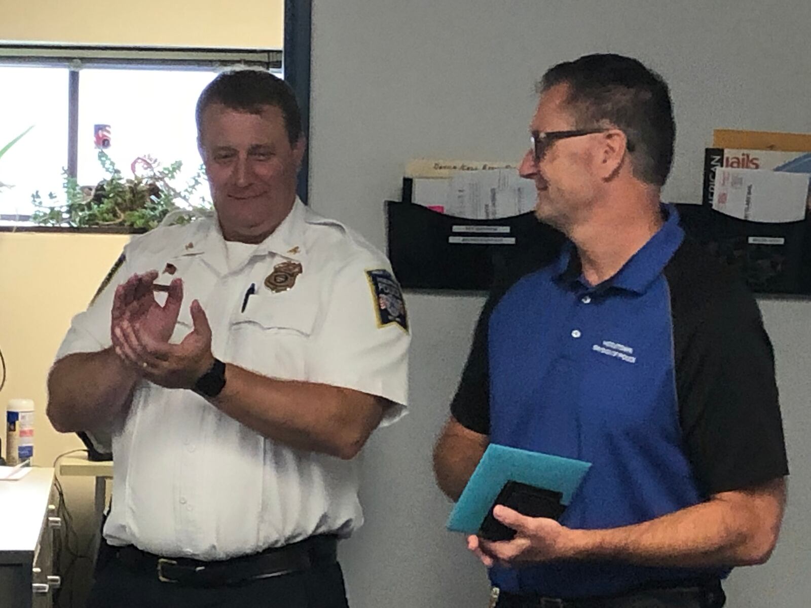 Middletown police Chief David Birk, left, applauds for Deputy Chief Scott Reeve, who retired last week after 35 years with the department. RICK McCRABB/STAFF