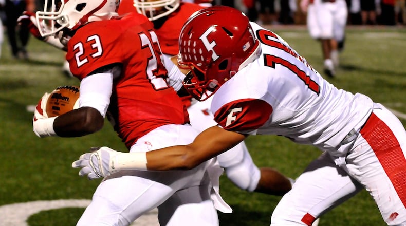 Fairfield’s Rudy Jones (10) brings down Colerain’s J.J. Davis (23) during the frist quarter of a Greater Miami Conference contest Oct. 14, 2016, at Colerain. The host Cardinals won 28-0. CONTRIBUTED PHOTO BY DAVID A. MOODIE