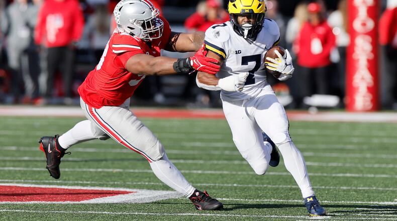 Ohio State defensive lineman Ty Hamilton, left, tackles Michigan running back Donovan Edwards during the second half of an NCAA college football game on Saturday, Nov. 26, 2022, in Columbus, Ohio. (AP Photo/Jay LaPrete)