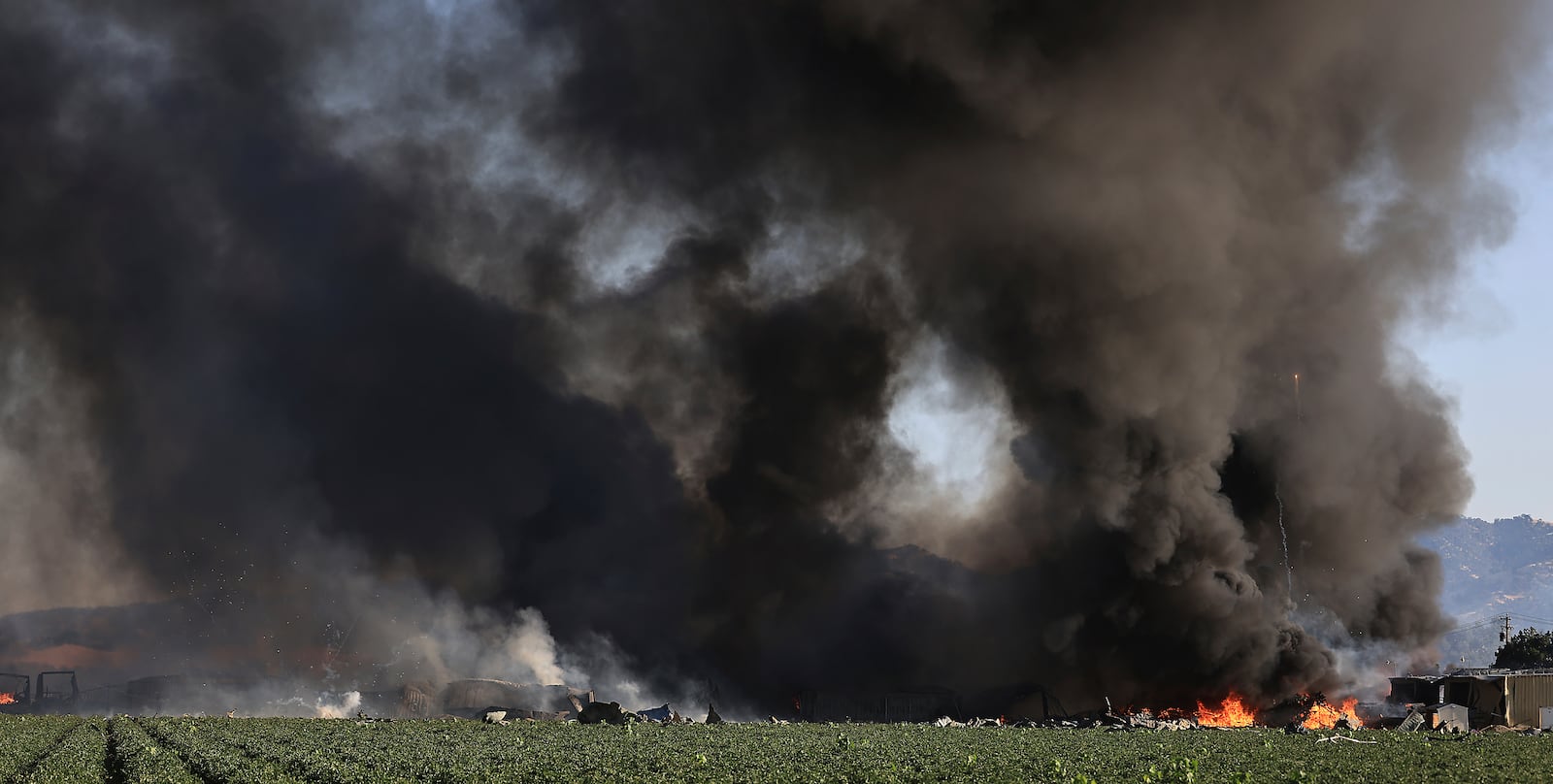 Smoke and flames rise during a fireworks warehouse explosion near Esparto, Calif., Tuesday, July 1, 2025. (Kent Porter/The Press Democrat via AP)