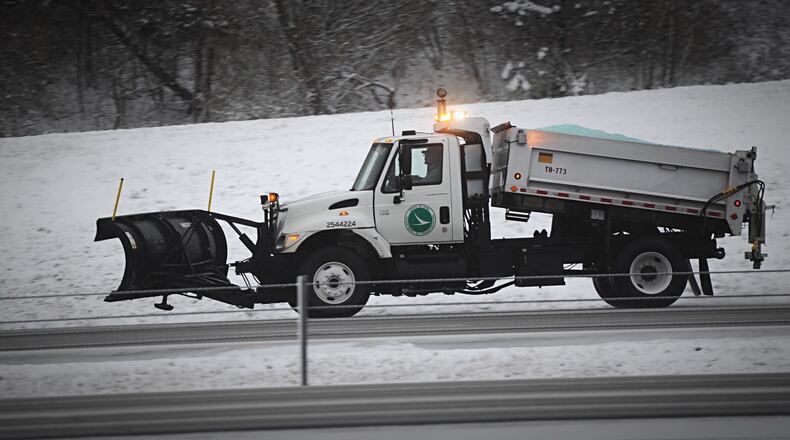 ODOT trucks spread salt along Interstate 675 near Indian Ripple Road early Tuesday morning after the area's first snowfall of 2020.  MARSHALL GORBY/STAFF