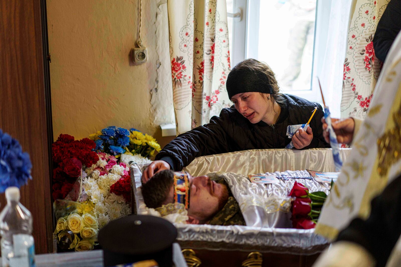 Olena cries at the coffin of her husband, Dmytro Shapovalov, a Ukrainian serviceman, during his funeral ceremony in Yosypivka village, Vinnytsia region, Ukraine, on Friday, June 13, 2025. (AP Photo/Evgeniy Maloletka)
